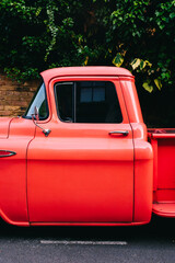 Shiny red vintage pickup truck parked on the street