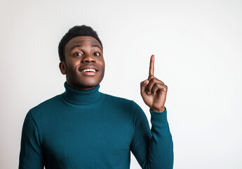 Excited Man in Blue Turtleneck Pointing Up – Portrait with Happy Expression, White Background, Ample Space for Text, High-Resolution Studio Photography for Advertising & Social Media Concepts