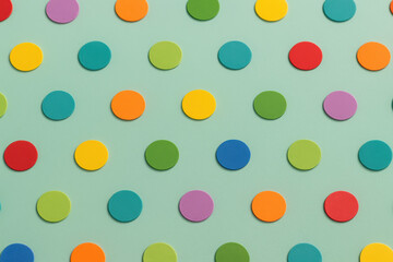 Colorful round dots arranged in geometric pattern on mint green background, vibrant minimalist abstract repetition concept