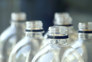 Close-up of bottle necks used in mass production of drinks. Symbolizes modern food packaging,...