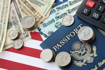 American US dollars money bills, passport and calculator on American flag close up