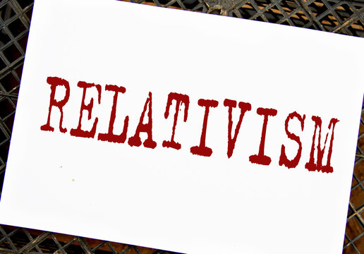 RELATIVISM - word on white sheet on black grid background