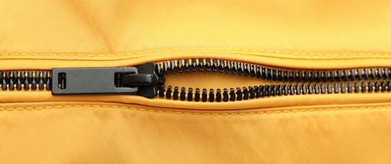 Black zipper on yellow clothes, closeup