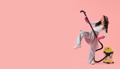 Happy housewife with vacuum cleaner singing on pink background with space for text