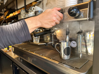 closeup of hands of barista  and coffee machine making coffee in cafe