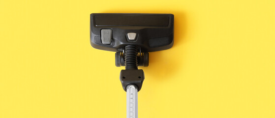Brush of modern vacuum cleaner on yellow background