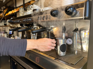 closeup of hands of barista  and coffee machine making coffee in cafe