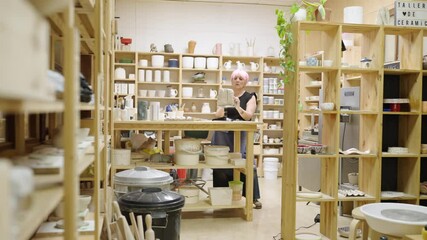 Ceramist managing inventory in pottery workshop