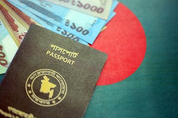 Bangladeshi taka money bills in big amount and passport lies on Bangladesh flag close up
