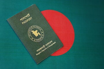 Bangladeshi passport lies on Bangladesh flag close up. Travel and citizenship