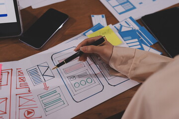Close up ux developer and ui designer brainstorming about mobile app interface wireframe design on...