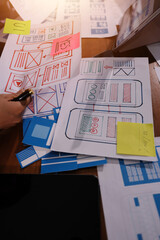 Close up ux developer and ui designer brainstorming about mobile app interface wireframe design on...