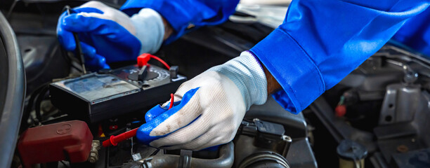 Close up auto mechanic hands holding tool fixing car in repair shop
