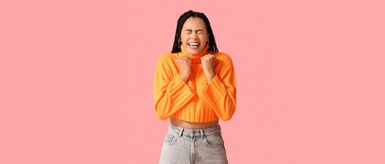 Happy African-American woman on pink background