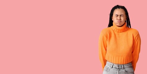 Angry African-American woman blowing cheeks on pink background with space for text