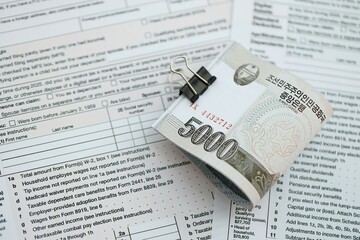 North Korean won money bills in big amount lies on table with tax forms close up