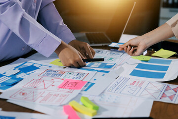 Close up ux developer and ui designer brainstorming about mobile app interface wireframe design on...