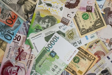 Big amount of money bills of different currencies and countries. Assortment background of international cash in big pile close up