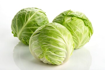 Obraz premium Fresh green cabbages arranged elegantly on a reflective surface, showcasing their crisp leaves and natural shine