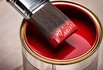A close-up view of a paintbrush dipped in vibrant red paint, ready for a fresh coat of color.