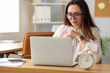 Young businesswoman working with laptop at table in office