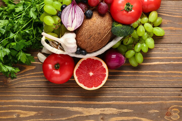 Wicker basket with different fresh fruits and vegetables on wooden background, closeup