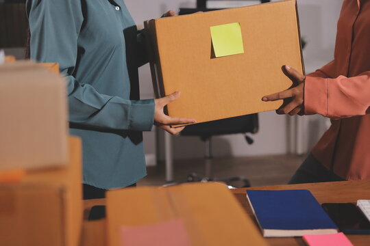 Startup SME small business entrepreneur of freelance Asian woman wearing apron using laptop and box to receive and review orders online to prepare to pack sell to customers, online sme business ideas.