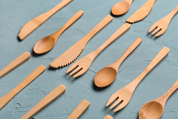 Wooden knives, forks and spoons on blue background