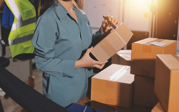 Startup SME small business entrepreneur of freelance Asian woman wearing apron using laptop and box to receive and review orders online to prepare to pack sell to customers, online sme business ideas.