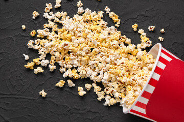 Bucket with tasty popcorn on black background