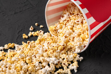 Bucket with tasty popcorn on black background