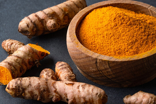 Turmeric with its magnificent orange color on a vintage black background