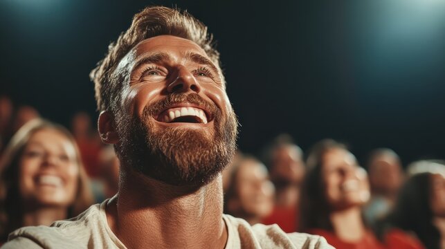 A joyful man laughing at a live performance, surrounded by a cheerful audience. The vibrant atmosphere showcases the happiness and excitement of shared entertainment.