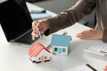 Real Estate Consultation. Professional discussing property options with miniature models.