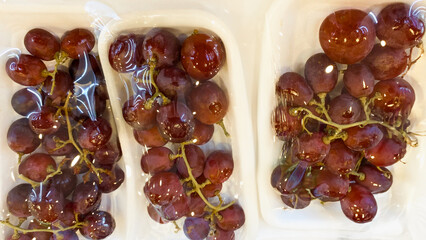 Grapes wrapped in plastic isolated on a clean white background in high quality, for health or diet promotion fruit product photos