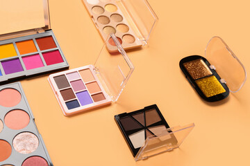 Beautiful palettes of eyeshadows on orange background