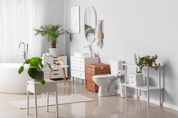 Interior of light bathroom with bathtub and toilet bowl