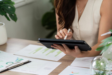Fototapeta premium Sustainable Business Practices. Professional woman using tablet for ESG analysis in modern office.