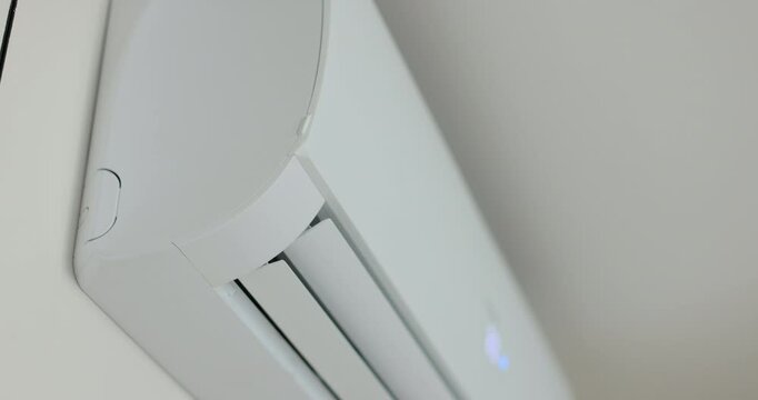 Close up of a air conditioner turning on and opening its air outlet. Modern air conditioning technologies.