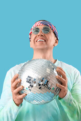 Cool mature man with disco ball on blue background, closeup