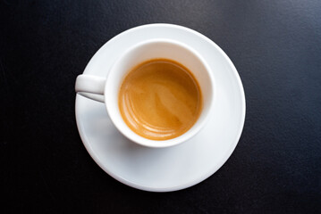 Cup of coffee espresso from above on black background