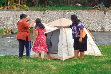 With the tent setup finally done, the children stand by, ready and excited to step into their...