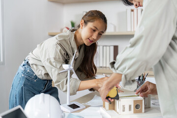 Hands-on Architectural Development. Female architect measuring a model structure.
