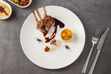 Grilled lamb chops with mashed potato, polenta cake and garnish