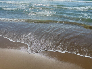 Close-up of soft waves lapping the sandy shore at Chirihama Beach, Ishikawa, Japan.
