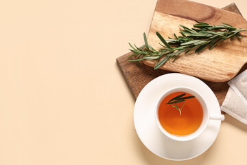 Cup of hot rosemary tea on beige background