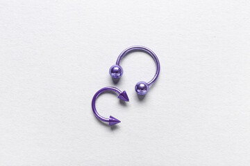 Purple circular barbells for piercing on white background