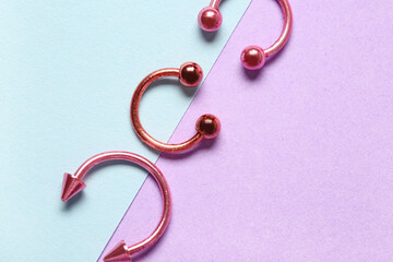 Pink circular barbells for piercing on color background