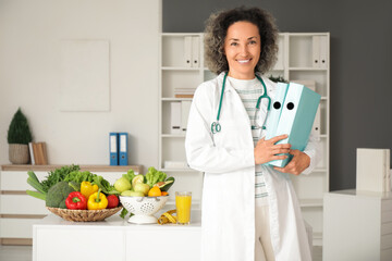 Mature female nutritionist with folders in office