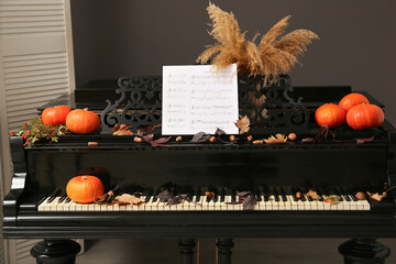 Fresh pumpkins and autumn decor on piano. Closeup